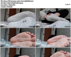 Girl feet grey socks at bed